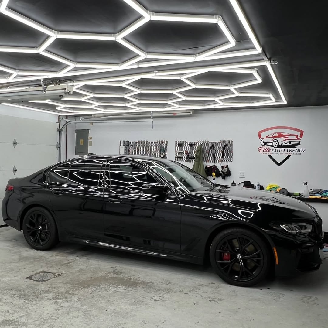 Black BMW with ceramic coating and window tint inside the Elite Auto Trendz shop in Fall River, MA